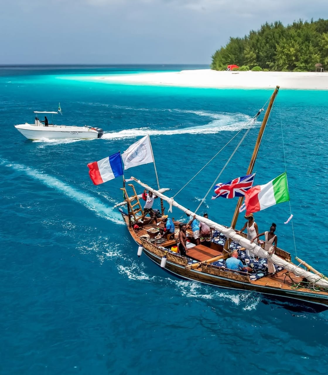A traditional dhow sailing through clear turquoise water off Zanzibar